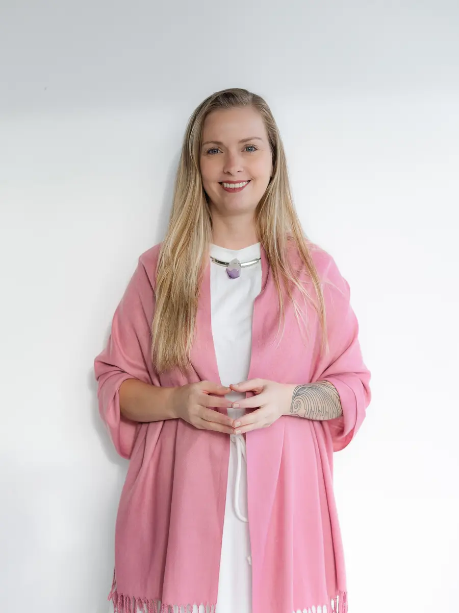 Retrato de Lairany Souza sorrindo, de xale rosa sobre vestido branco